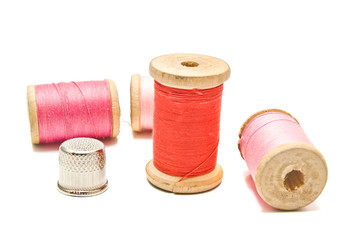 thimble and spools of thread on white