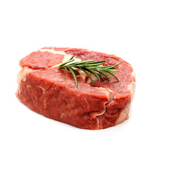 Raw ribeye steak garnished with sprig of rosemary