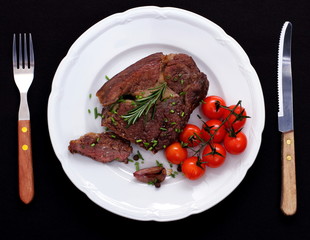 Rib eye steak with cherry tomatoes, garlic, rosemary