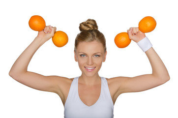 Beautiful woman with dumbbells from ripe oranges