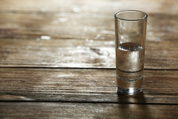 Glass of clean mineral water on rustic wooden planks background