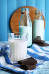 Glass and bottles of milk with chocolate chunks