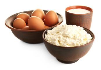 Cottage cheese, milk and eggs in pottery isolated on white
