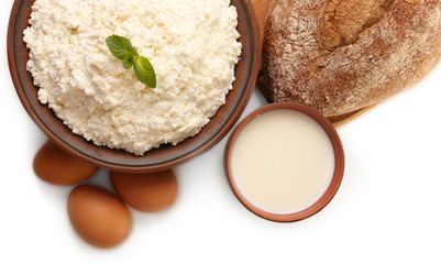 Dairy products with eggs and loaf of bread isolated on white