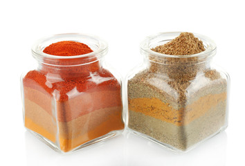 Different kinds of spices in glass bottles isolated on white