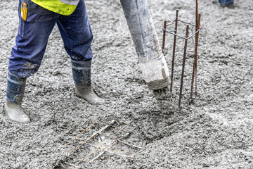 construction site, worker pouring concrete with pump tube