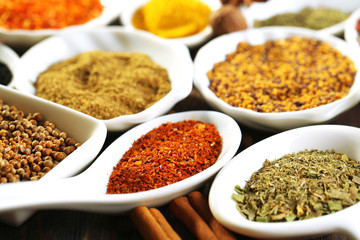 Different kinds of spices in ceramics spoons, close-up,