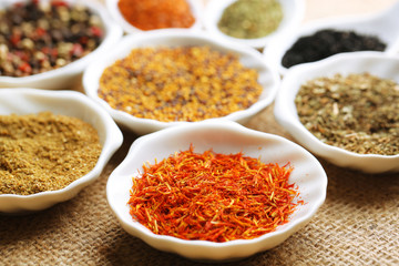 Different kinds of spices in ceramics spoons, close-up,