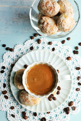Cup of coffee and tasty cookie on color wooden background