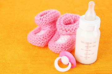 Baby milk bottle, pacifier and babys bootees