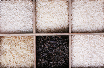 Fototapeta premium Different types of rice in box on wooden background
