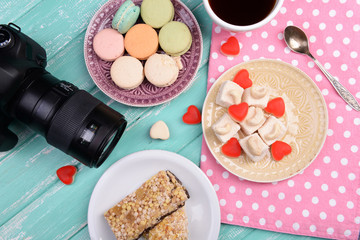 Different sweets and photo camera on table top view