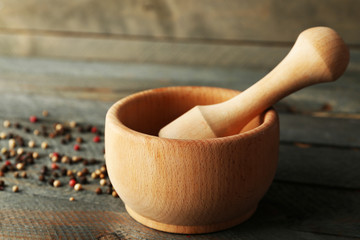 Mixture of peppers in mortar on wooden background