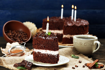 Delicious chocolate cake on table on blue background