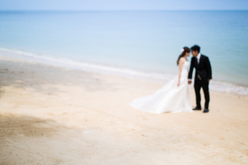 Out of focus of Bride and groom on tropical beach