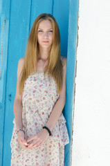 Fototapeta premium Fashion blonde against the blue door in mykonos island