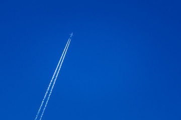 Airplane In The Sky With Plane Trails