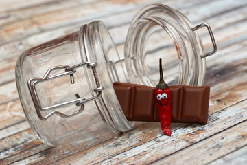 lustige rote Chilli Schote mit Schokolade vor Einmachglas