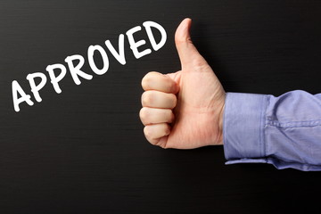 Thumbs up For the Approved on a blackboard