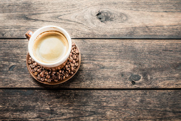 Coffee cup and coffee beans on old wooden table