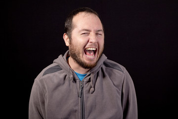 young man laughing isolated on black background