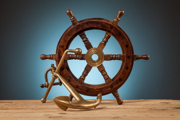 Obraz premium maritime adventure anchor and old wooden steering wheel