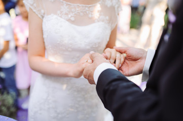 Bride and groom's hands with wedding rings.