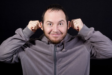 Naklejka premium man pulling his ears isolated on black background