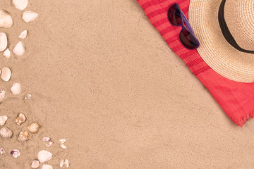 Fototapeta na wymiar sandy beach background, sunglasses, hat seashells copy space