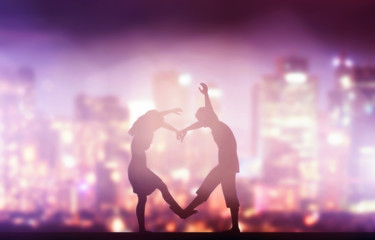 Happy couple in love making heart shape. City at night