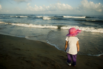 Pretty little girl on the beach near sea