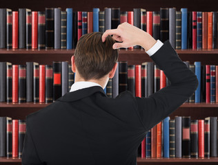 Young Man In A Suit Scratching His Head