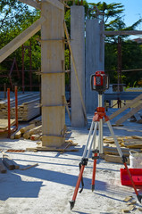 Electronic level on a tripod set up at a construction site