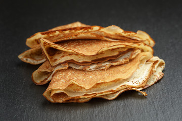 thin crepes or blinis folded in triangles on slate board