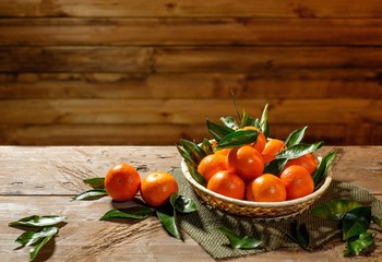 Basket with tasty tangerines on a wooden table