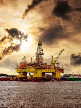 Oil rig in the harbor against a dramatic sky.