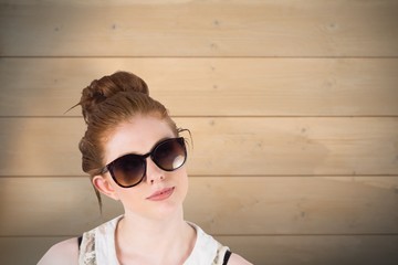 Composite image of hipster redhead wearing large sunglasses