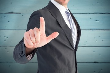 Composite image of businessman pointing with his finger