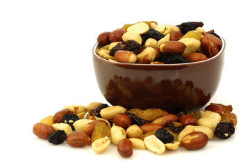Fototapeta na wymiar mixed peanuts and raisins in a brown bowl on a white background