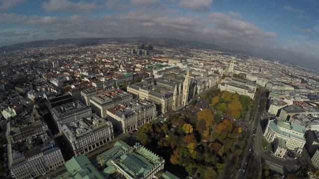 Camera flying above Vienna with a view on Rathaus and park.