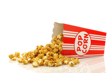 caramel popcorn in a paper popcorn cup on a white background © tpzijl