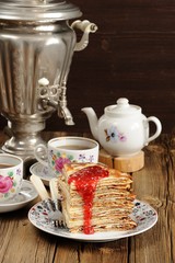 Russian bliny with raspberry jam, vintage samovar and teaware