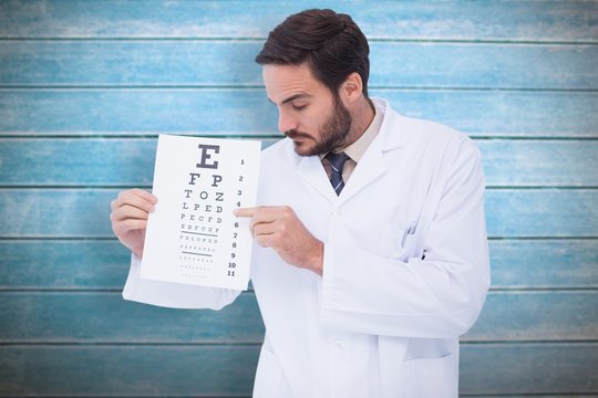 Composite image of doctor in lab coat showing eye test