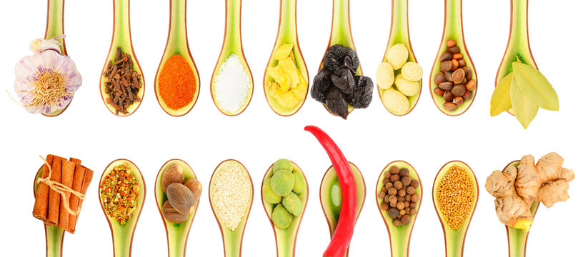 Collection of spices in spoons on a white background
