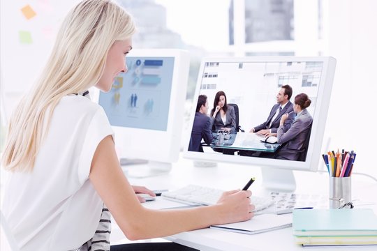 Composite image of casual young woman using computer in office