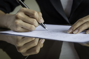closeup of woman hands signing a contract