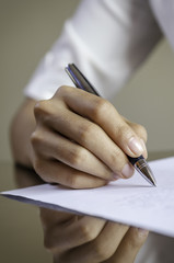 closeup of woman hand signing a contract