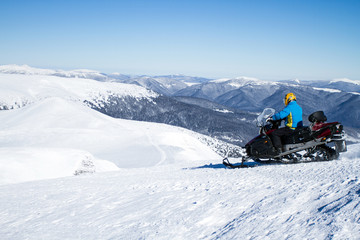 Man on snowmobile in winter mountain