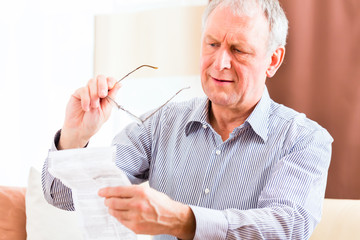 Senior liest mit Altersweitsichtigkeit Beipackzettel 