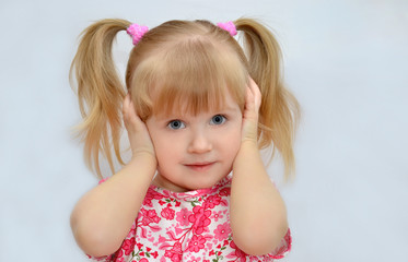 девочка закрыла уши руками